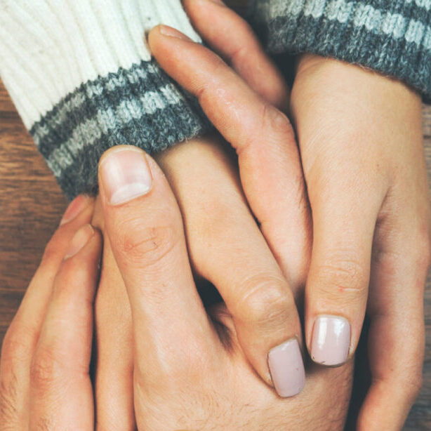 man and a woman holding hands at a wooden table